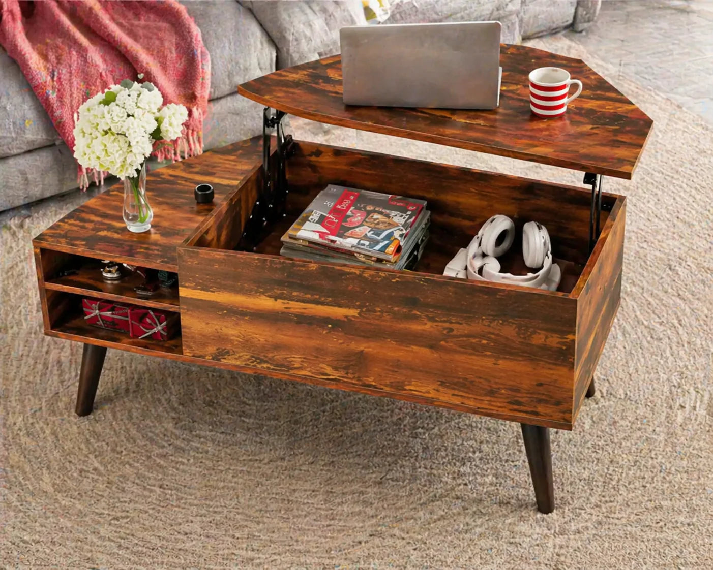 Wooden coffee table with lift-top design, displaying a laptop, mug, and books in a living room setting.