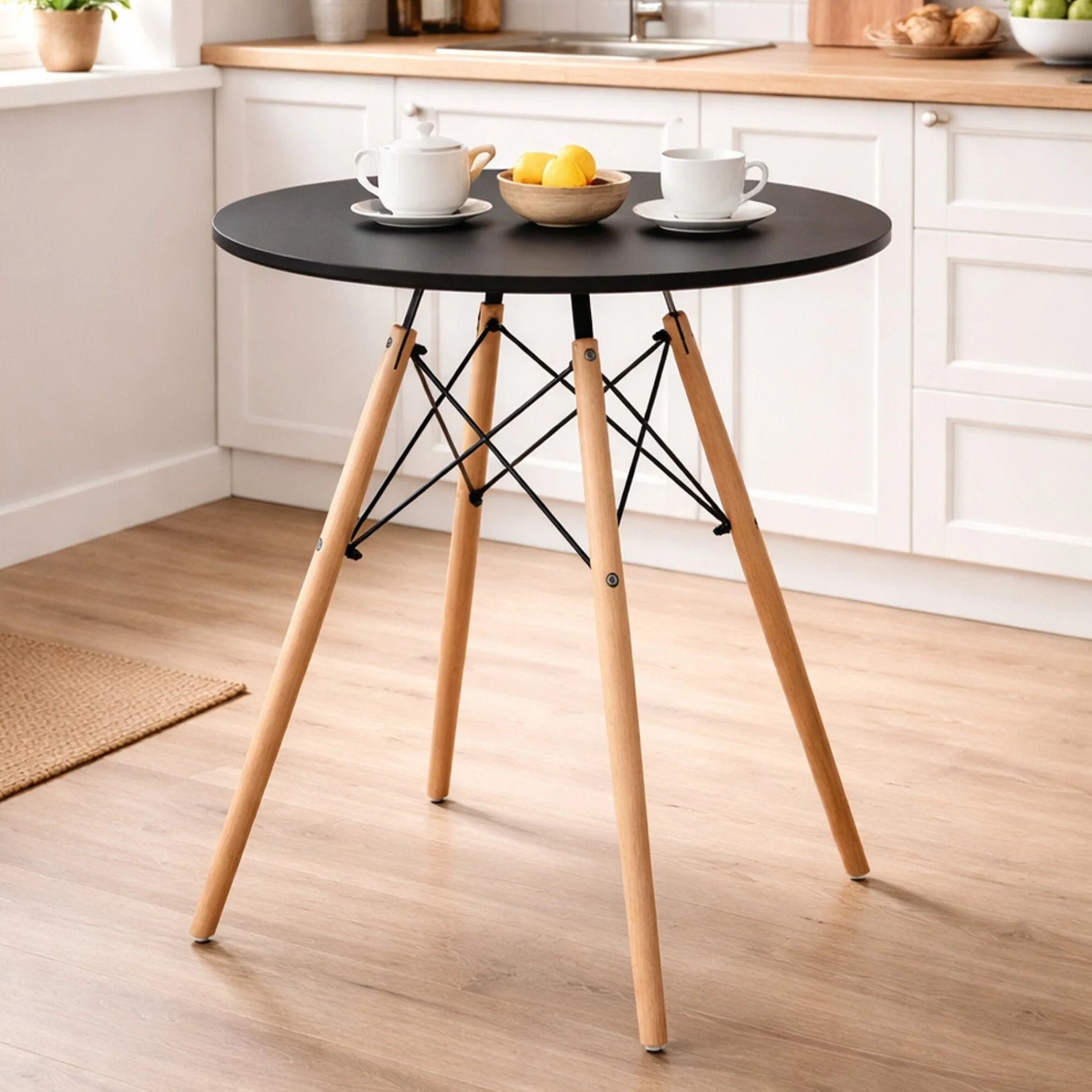Round black table with wooden legs in a kitchen setting